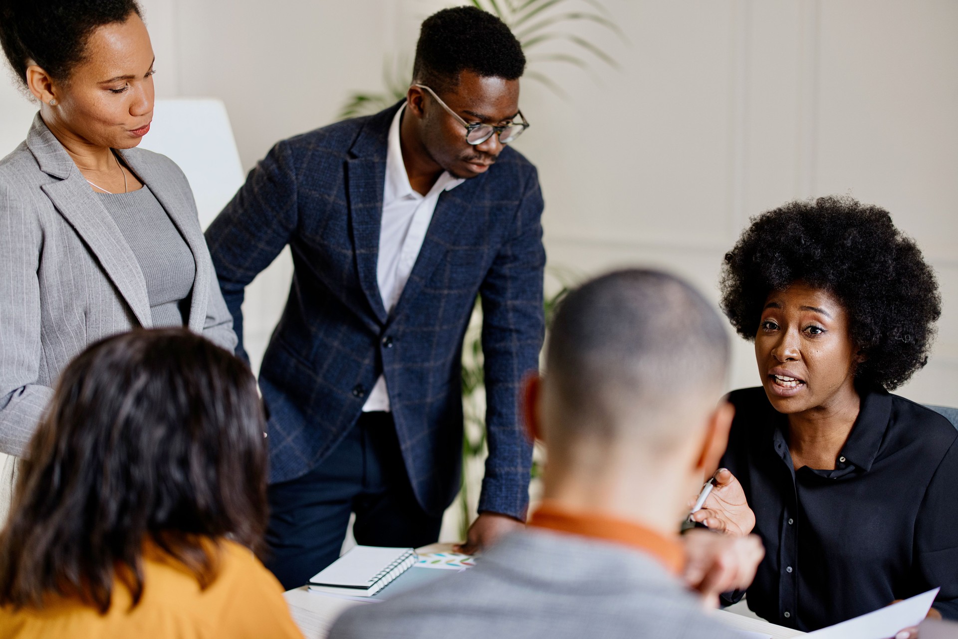 Five black African colleagues talking and strategizing in the office